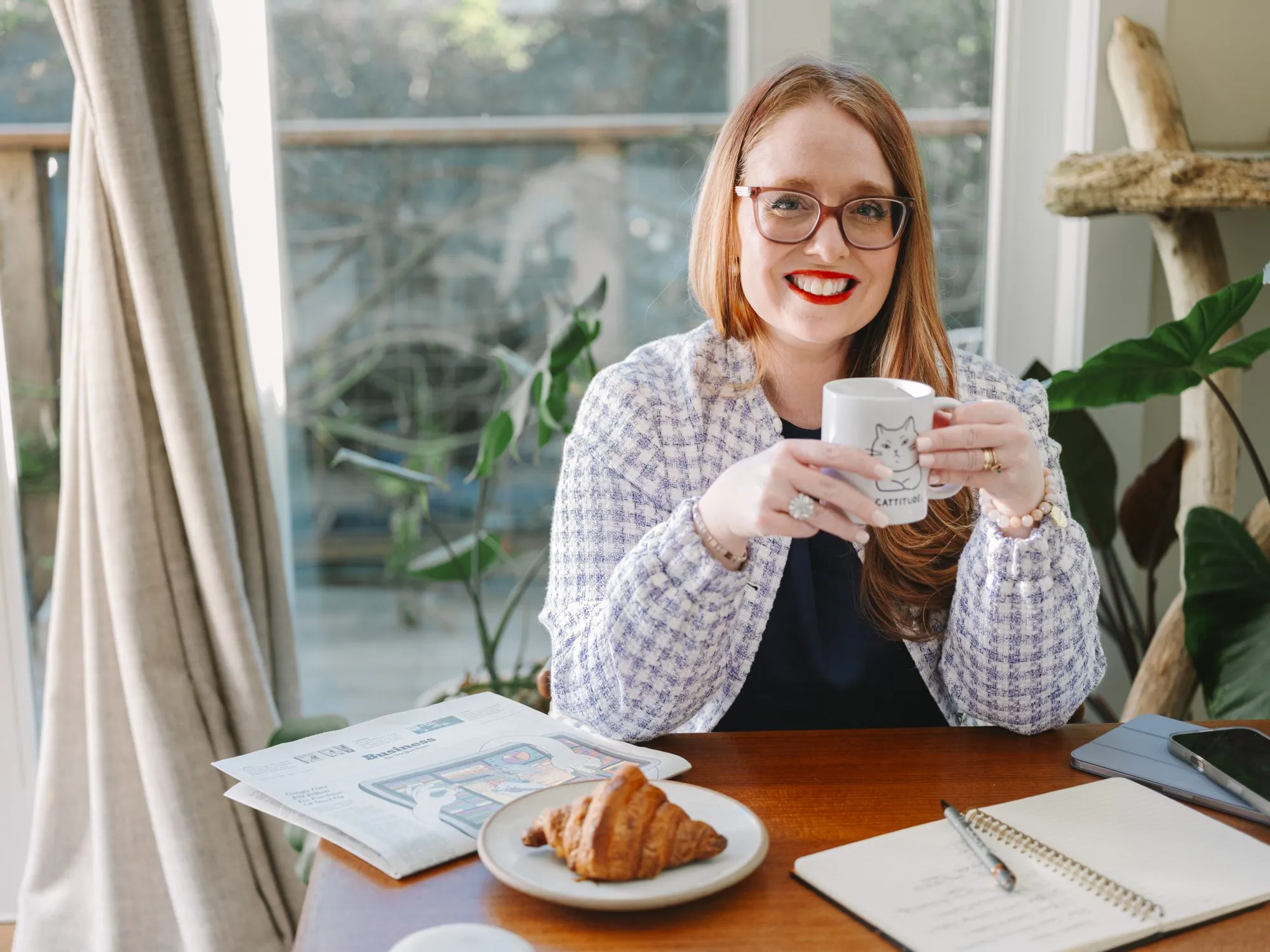 Dr. Monica Rysavy smiling over a cup of tea at a sunny window table